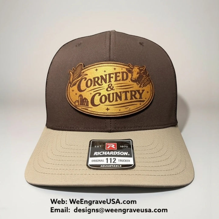 WeEngrave USA brown and tan Richardson 112 trucker hat with engraved leather patch that says "CornFed &amp; Country" with corn and cow graphics.